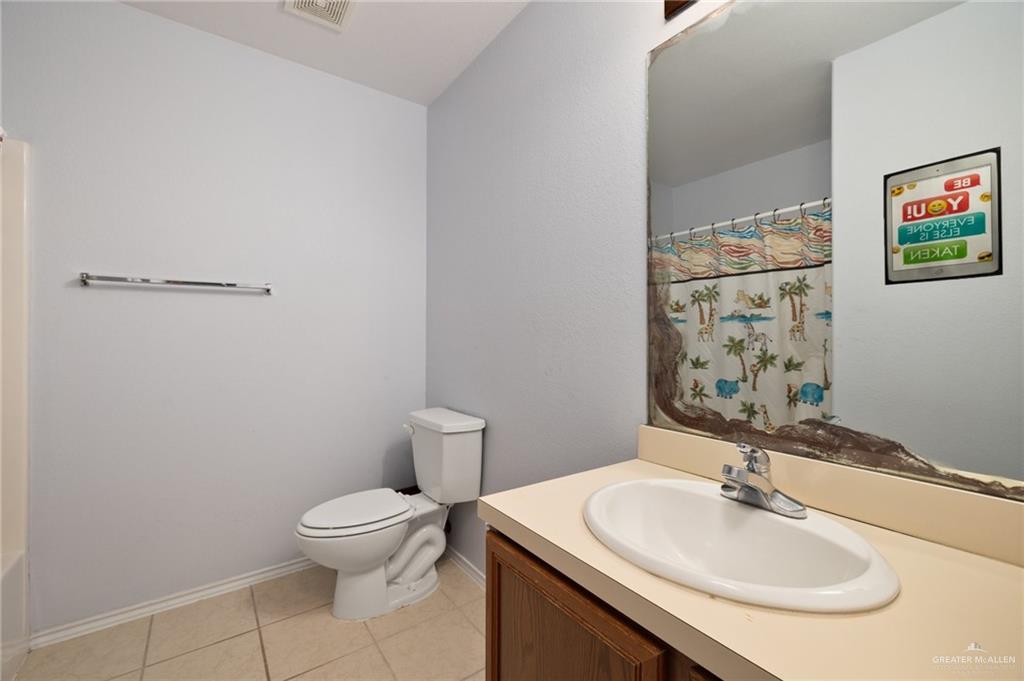 7105 North 40th Street McAllen, TX 78504 - Photo 12 of 13 a bathroom with a toilet sink and mirror