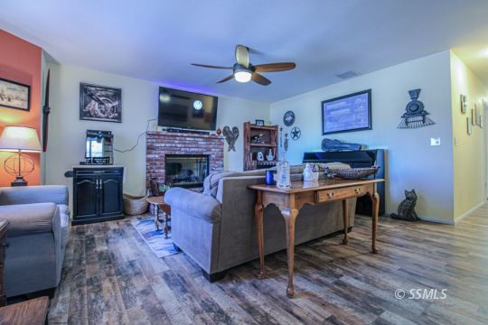 324 Sims Street Ridgecrest, CA 93555 - Photo 9 of 40 a living room with furniture a flat screen tv and a fireplace