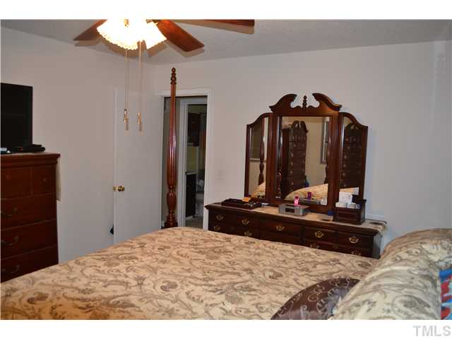 7712 Prospector Place Raleigh, NC 27615 - Photo 11 of 16 a bedroom with a bed and a mirror