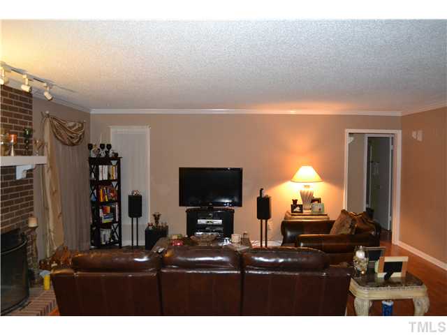 7712 Prospector Place Raleigh, NC 27615 - Photo 2 of 16 a living room with fireplace furniture and a flat screen tv