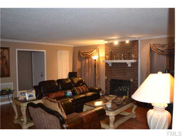 7712 Prospector Place Raleigh, NC 27615 - Photo 3 of 16 a living room with furniture and a fireplace