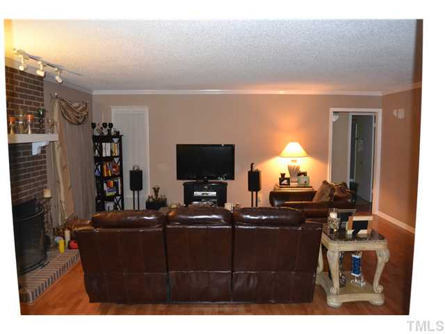 7712 Prospector Place Raleigh, NC 27615 - Photo 4 of 16 a living room with furniture a flat screen tv and a lamp