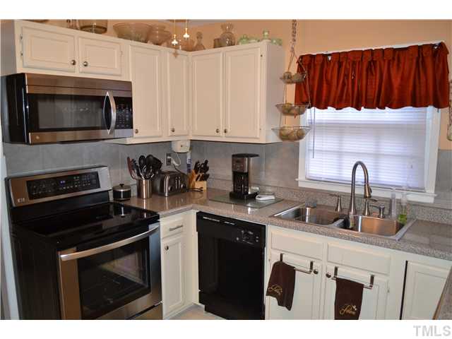 7712 Prospector Place Raleigh, NC 27615 - Photo 8 of 16 a kitchen with stainless steel appliances a stove a sink a microwave and cabinets