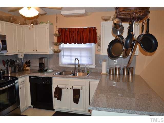 7712 Prospector Place Raleigh, NC 27615 - Photo 9 of 16 a kitchen with a sink a stove and cabinets