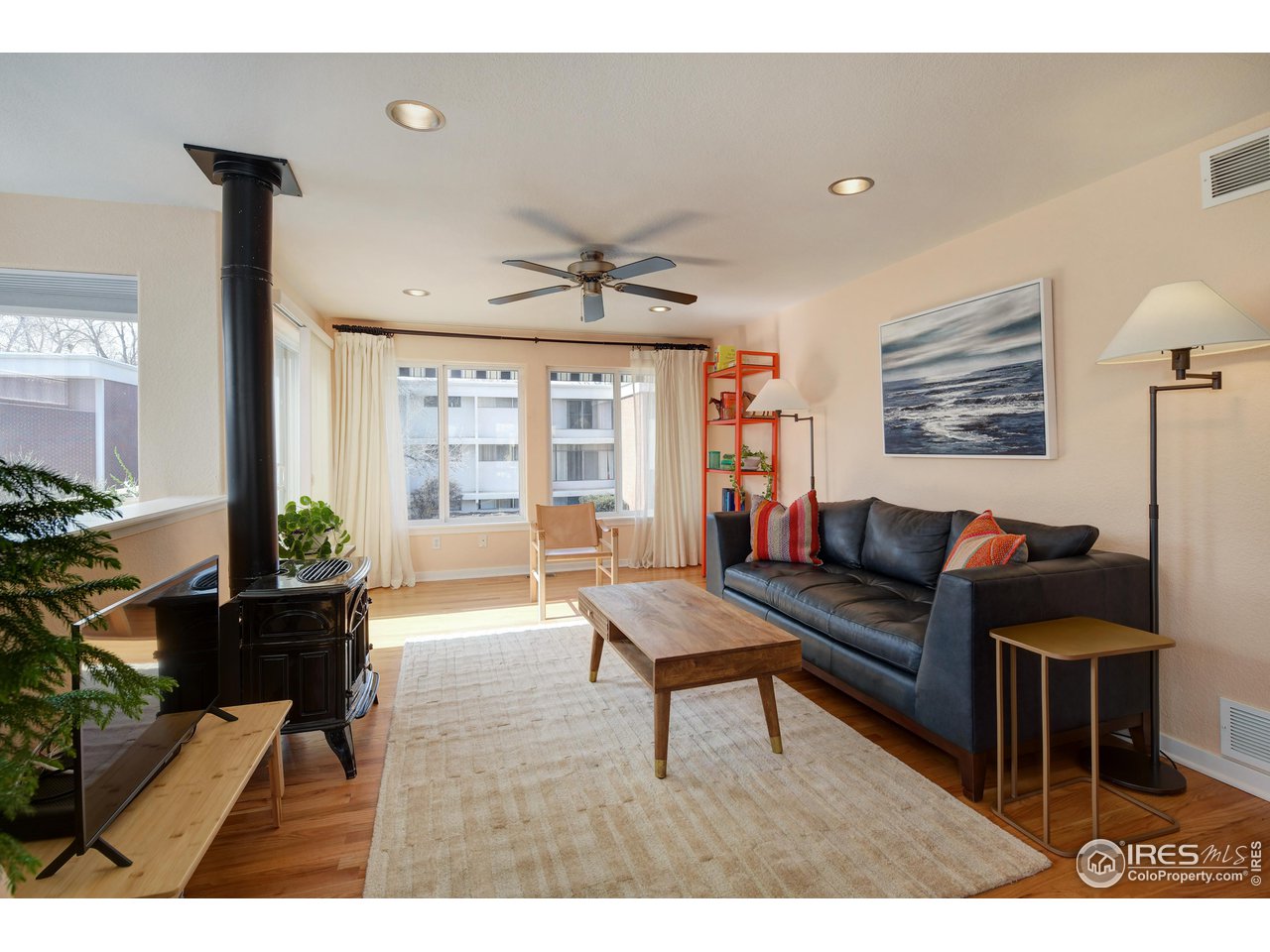 a living room with furniture a table and a large window