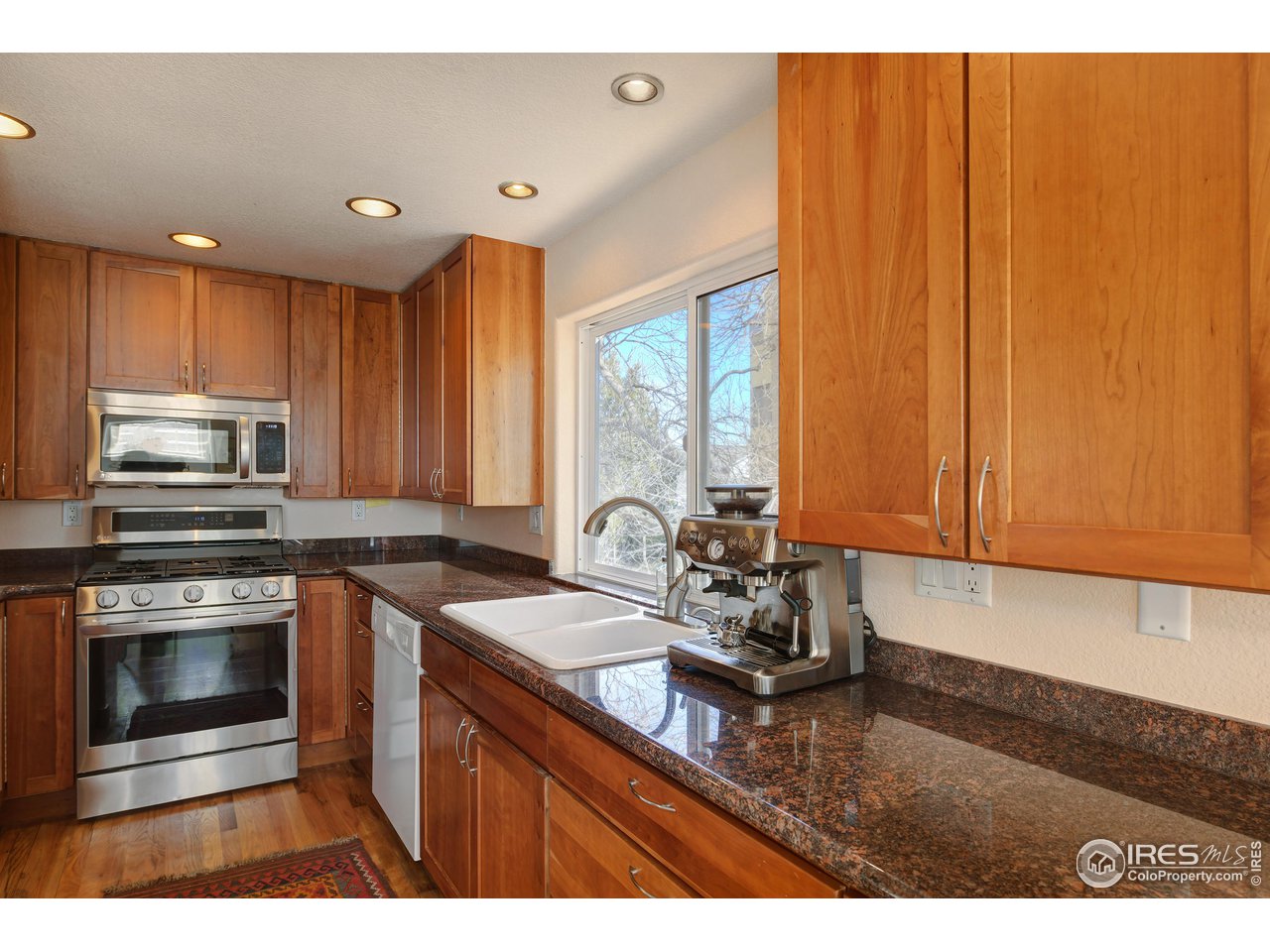 2701 Mapleton Avenue, Unit C Boulder, CO 80304 - Photo 11 of 34 a kitchen with kitchen island granite countertop a sink cabinets and stainless steel appliances