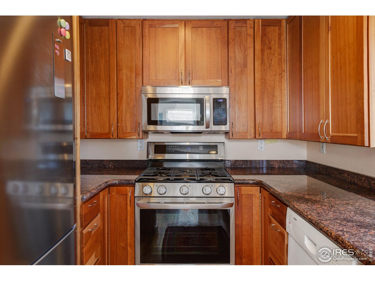 2701 Mapleton Avenue, Unit C Boulder, CO 80304 - Photo 13 of 34 a kitchen with granite countertop a stove top oven microwave and cabinets