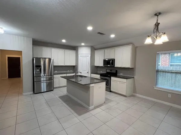 a kitchen with stainless steel appliances granite countertop a refrigerator and a stove top oven