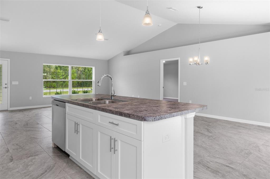 16375 Kakawi Road Brooksville, FL 34614 - Photo 12 of 30 a kitchen with granite countertop a stove and a sink