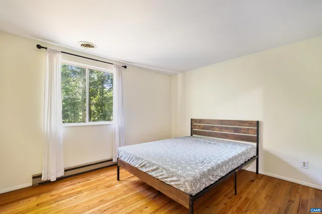 a bedroom with a bed and wooden floor