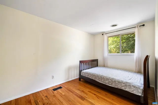 a bedroom with a bed and wooden floor