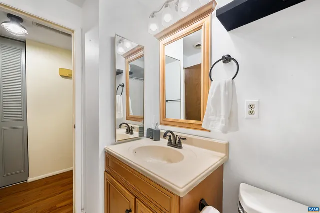 a bathroom with a sink vanity mirror and toilet