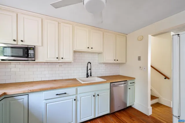 a kitchen with white cabinets and white appliances