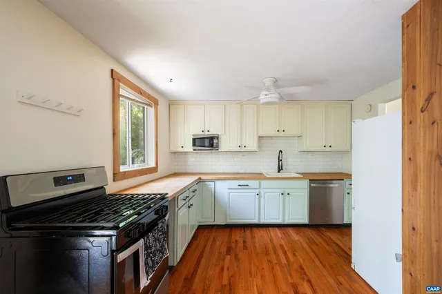 a kitchen with a sink stove top oven and cabinets