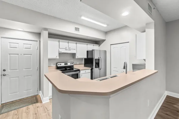 a kitchen with kitchen island a stove a sink and a refrigerator