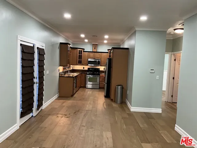 a kitchen with stainless steel appliances granite countertop a refrigerator and a stove top oven