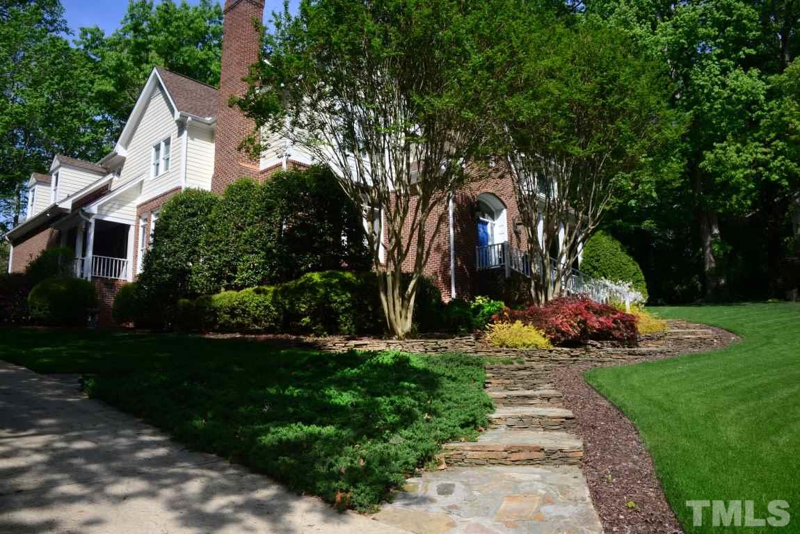 a front view of a house with a yard and a garden