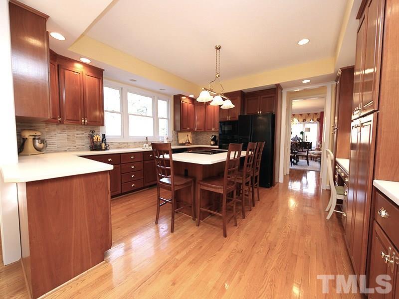 8808 Ross Court Raleigh, NC 27613 - Photo 7 of 25 a kitchen with a dining table chairs wooden floor and appliances