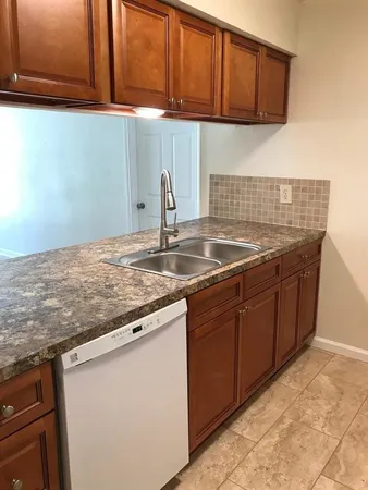 a kitchen with granite countertop a sink and cabinets