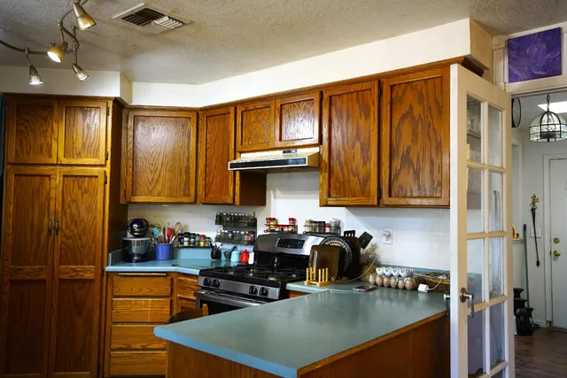 a kitchen with stainless steel appliances granite countertop a refrigerator and a stove top oven