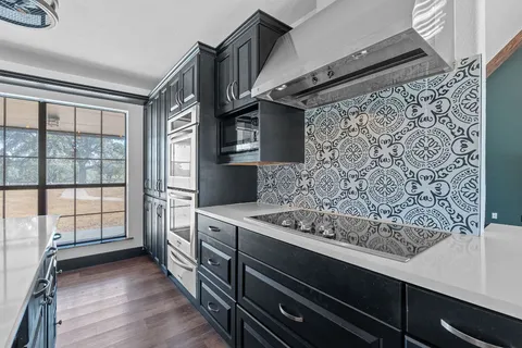 a kitchen with stainless steel appliances kitchen island granite countertop a stove a sink and a microwave