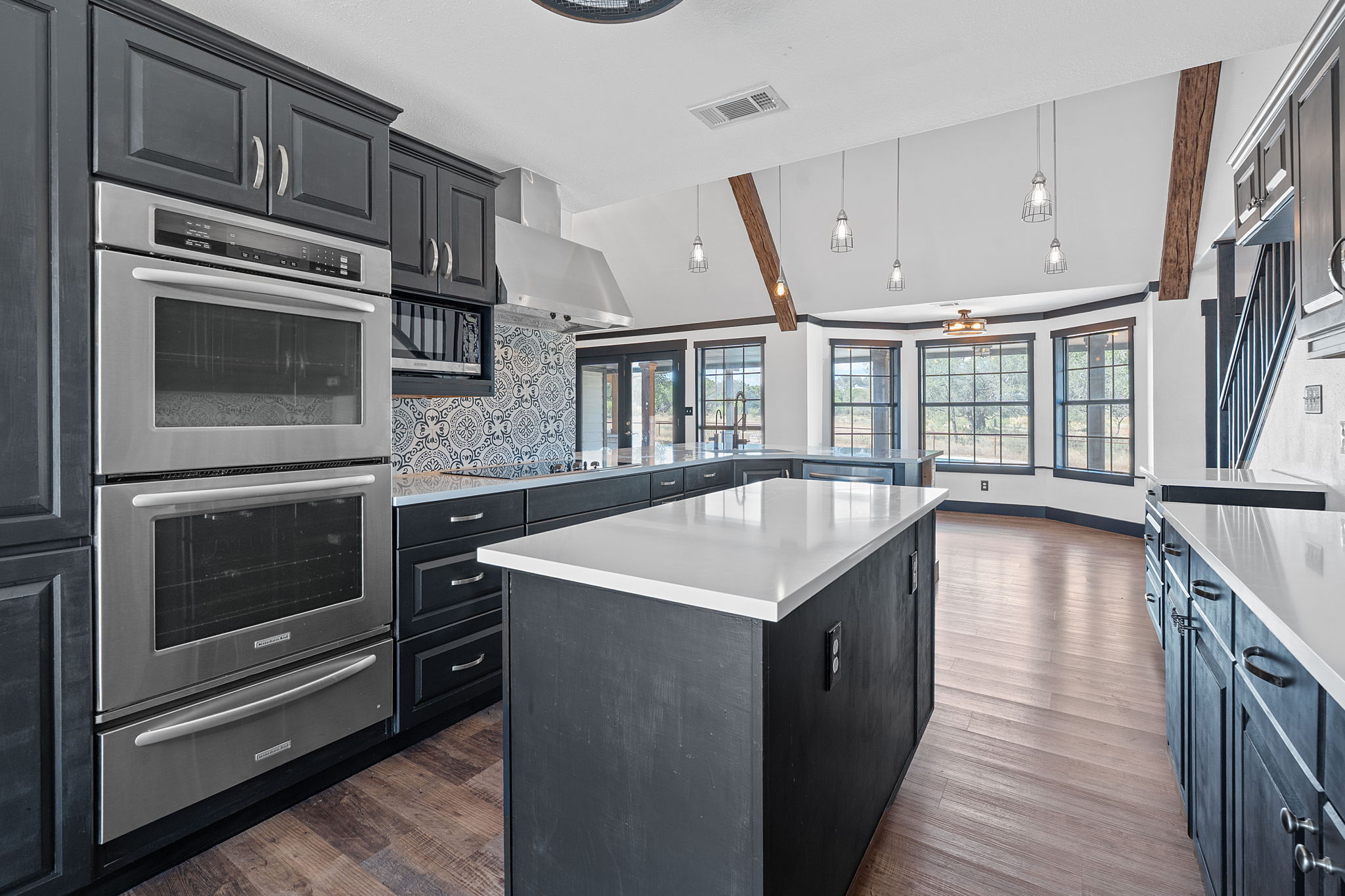 404 County Road 421 Spicewood, TX 78669 - Photo 12 of 31 a kitchen with stainless steel appliances kitchen island granite countertop a stove a sink and a microwave