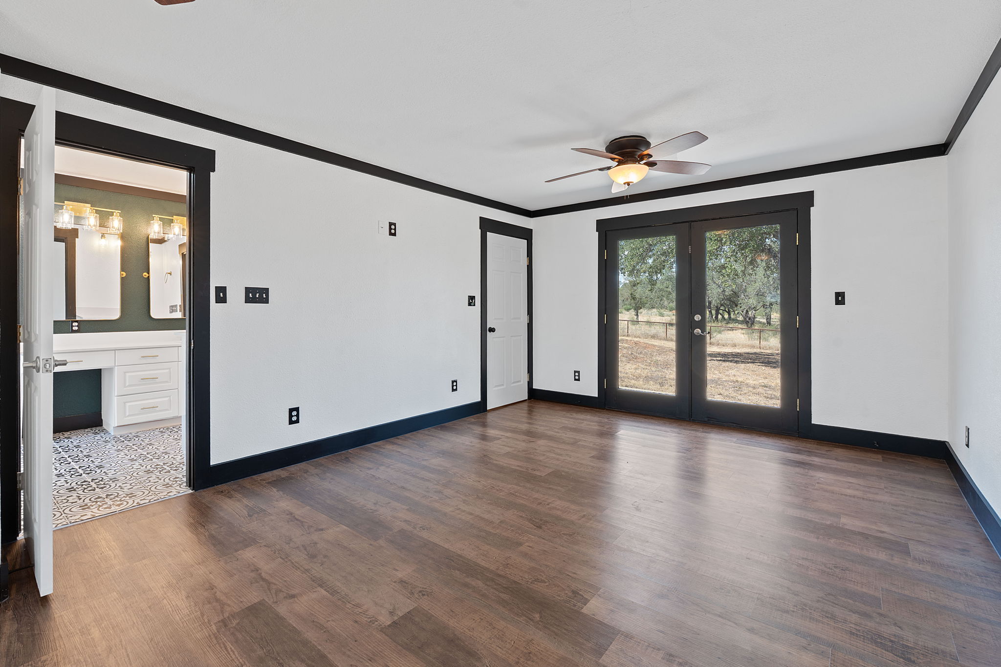 404 County Road 421 Spicewood, TX 78669 - Photo 15 of 31 an empty room with wooden floor chandelier and windows