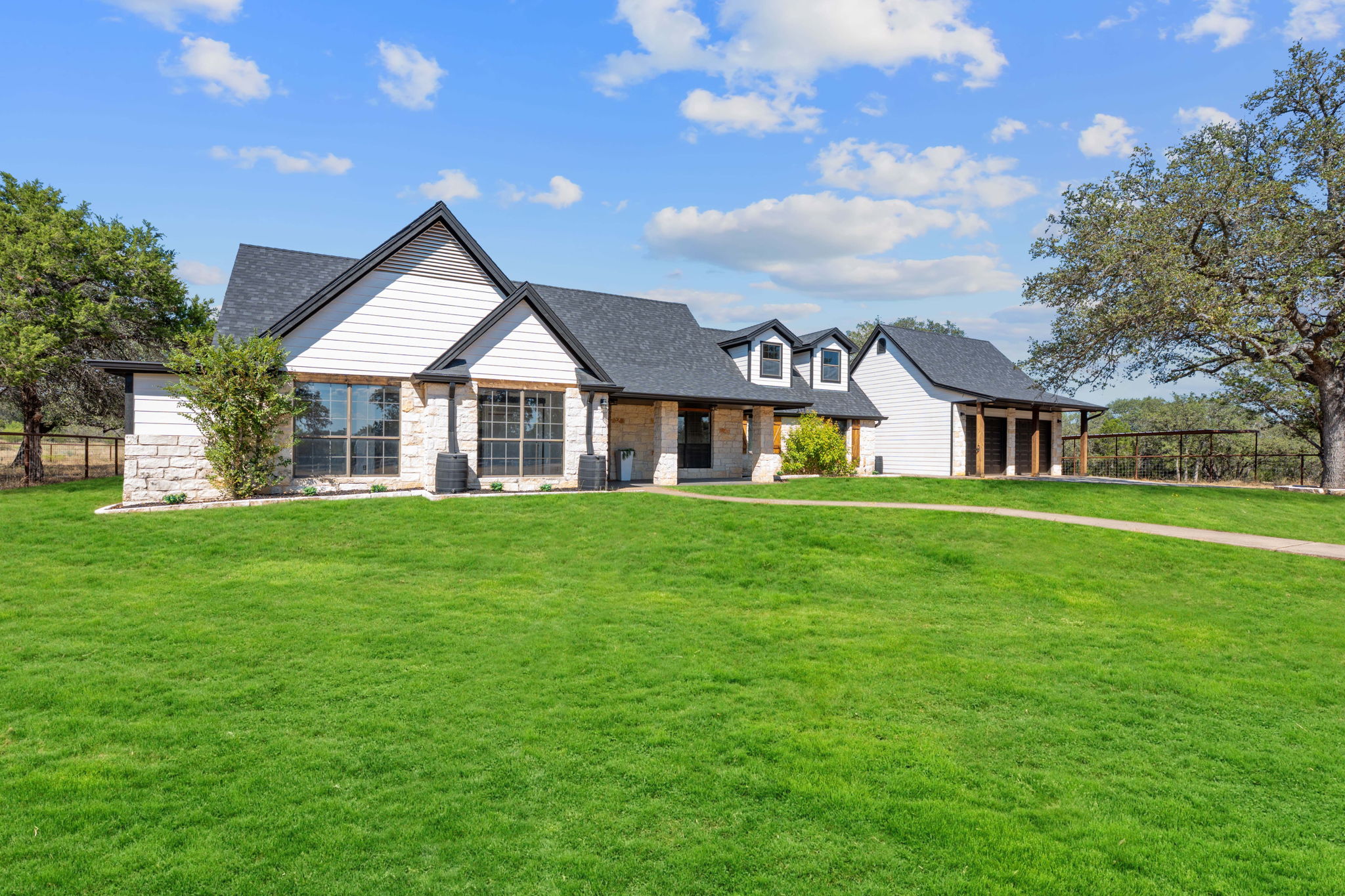 404 County Road 421 Spicewood, TX 78669 - Photo 2 of 31 a front view of house with yard and green space