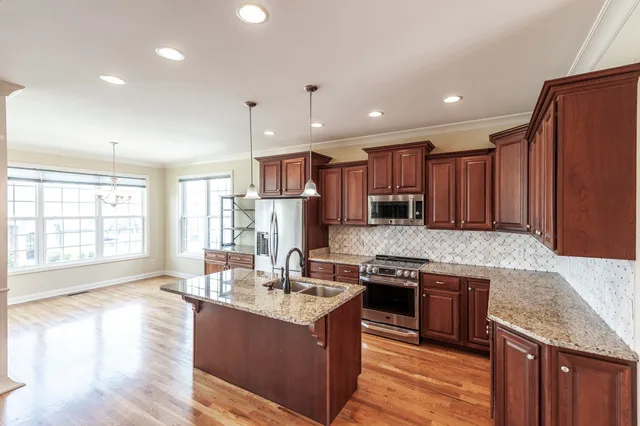 a kitchen with stainless steel appliances granite countertop a sink stove and refrigerator