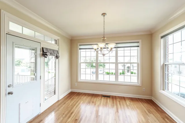 a view of an empty room with glass door and windows