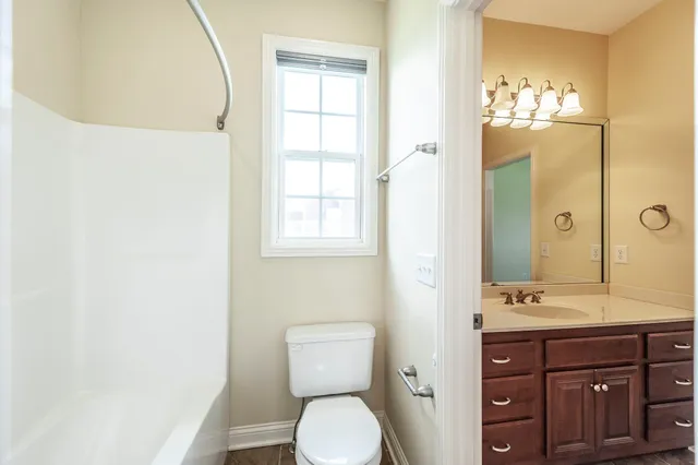 a bathroom with a toilet a sink and mirror