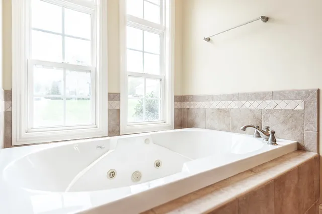 a bathroom with a bathtub and next to a window