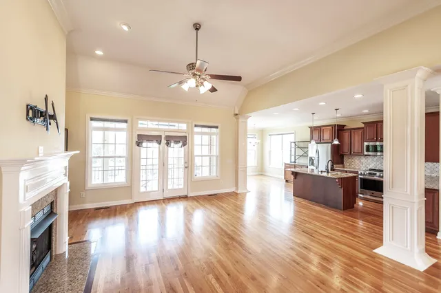 a view of a living room and kitchen with furniture wooden floor and windows