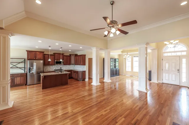 a large kitchen with stainless steel appliances kitchen island granite countertop a large island in the center