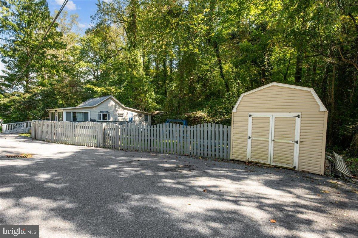 3330 1st Street Port Republic, MD 20676 - Photo 18 of 20 a view of a small house with a small yard and a large tree
