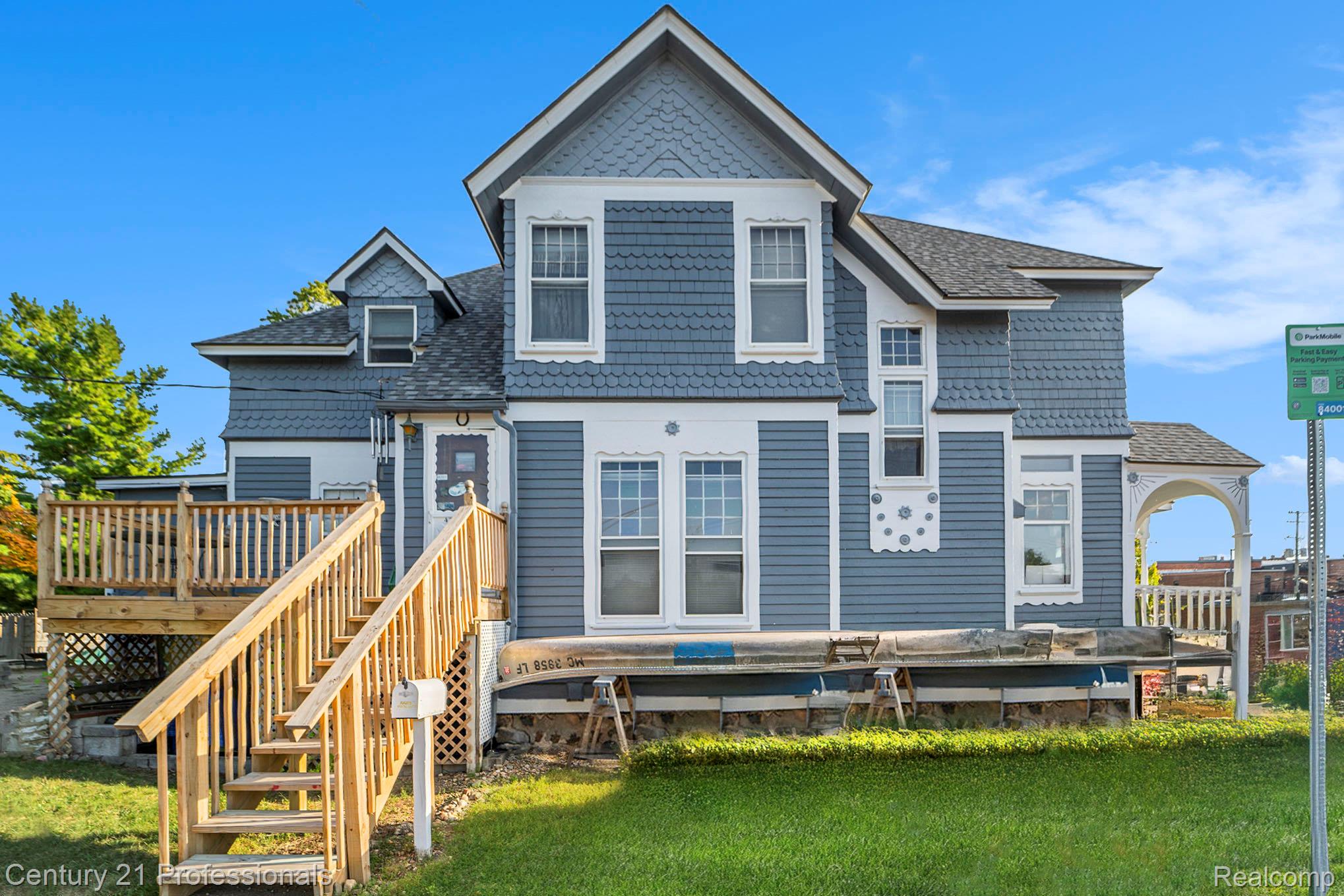 428 East Street Rochester, MI 48307 - Photo 25 of 30 Rear view of house featuring a lawn, roof with shingles, a deck, and stairway