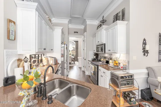 a kitchen with stainless steel appliances kitchen island granite countertop a sink and cabinets