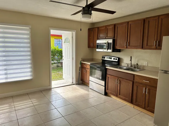 a kitchen with stainless steel appliances granite countertop a stove a sink and a microwave