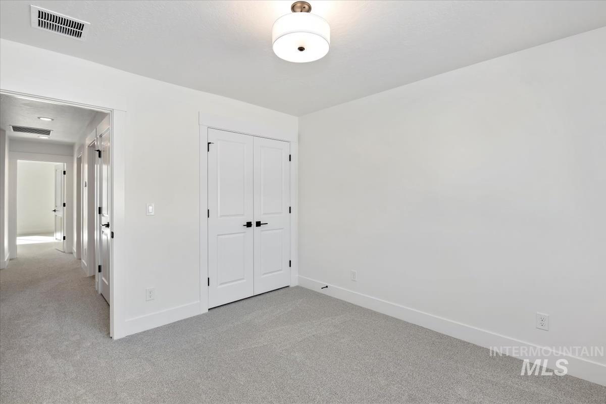 752 South Calhoun Lane Star, ID 83669 - Photo 24 of 45 Bedroom featuring light gray carpeting, white walls, and a ceiling-mounted light fixture