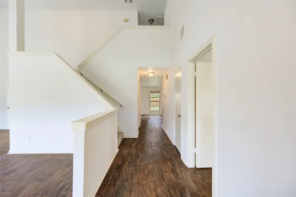 a view of a hallway with wooden floor
