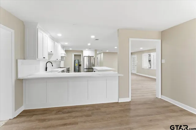 a kitchen with stainless steel appliances white cabinets and a refrigerator