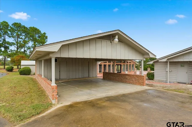 a view of swimming pool with lawn chairs under an umbrella