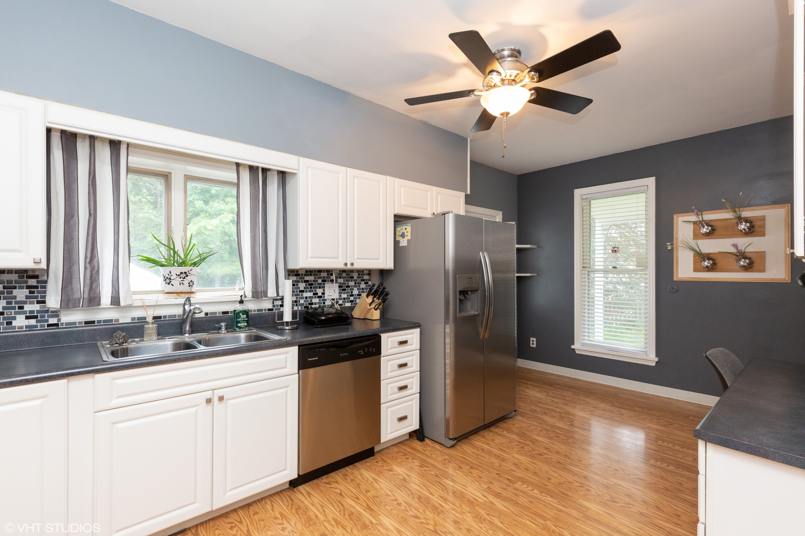 212 Lovell Street Elgin, IL 60120 - Photo 7 of 12 a kitchen with stainless steel appliances granite countertop a refrigerator a sink a stove a dining table and chairs with wooden floor