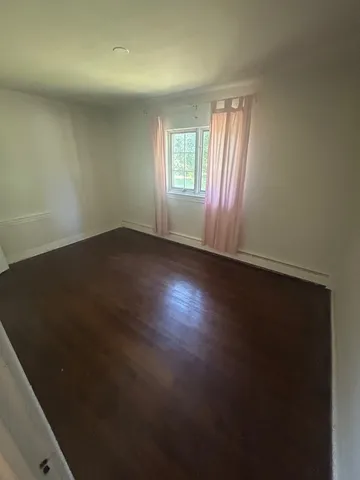 an empty room with wooden floor and closet