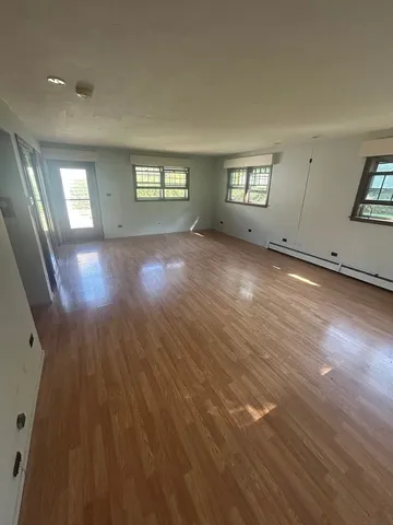 wooden floor in an empty room with a window
