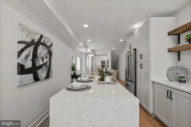 a kitchen with white cabinets and refrigerator