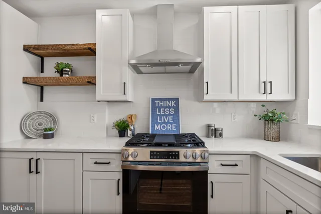 a kitchen with a sink stove and wooden floor