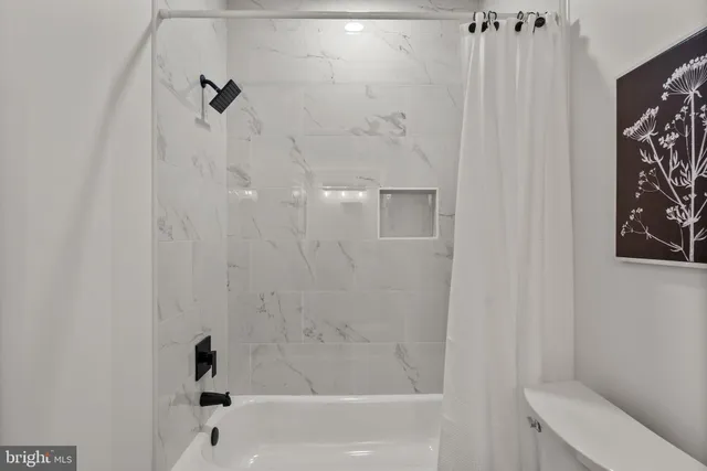 a bathroom with a toilet a sink a mirror a vanity and shower