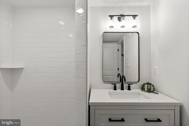 a view of a hallway with wooden floor and a bathroom