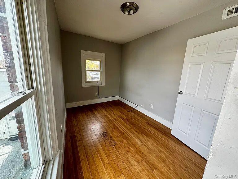 9 South Clinton Street, Unit 2 Poughkeepsie, NY 12601 - Photo 6 of 10 an empty room with wooden floor and windows